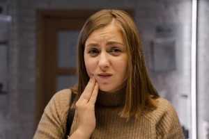 Eine Frau, die sich fragt, was man gegen Zahnschmerzen tun kann?