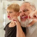 Ein Junge und sein Vater putzen aufmerksam ihre Zähne.