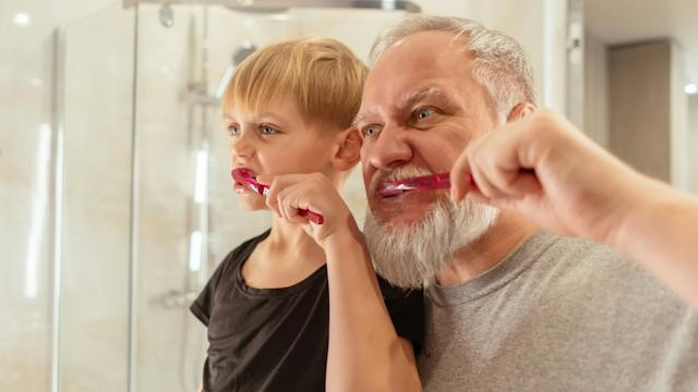 Ein Junge und sein Vater putzen aufmerksam ihre Zähne.